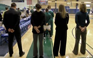 Photo by Ethan Magoc: Mercyhurst College coach Deanna Richard (middle right) stands with her assistant coaches during the national anthem prior to her team's game against Clarion University on Wednesday, Jan. 19, 2011, at the Mercyhurst Athletic Center.